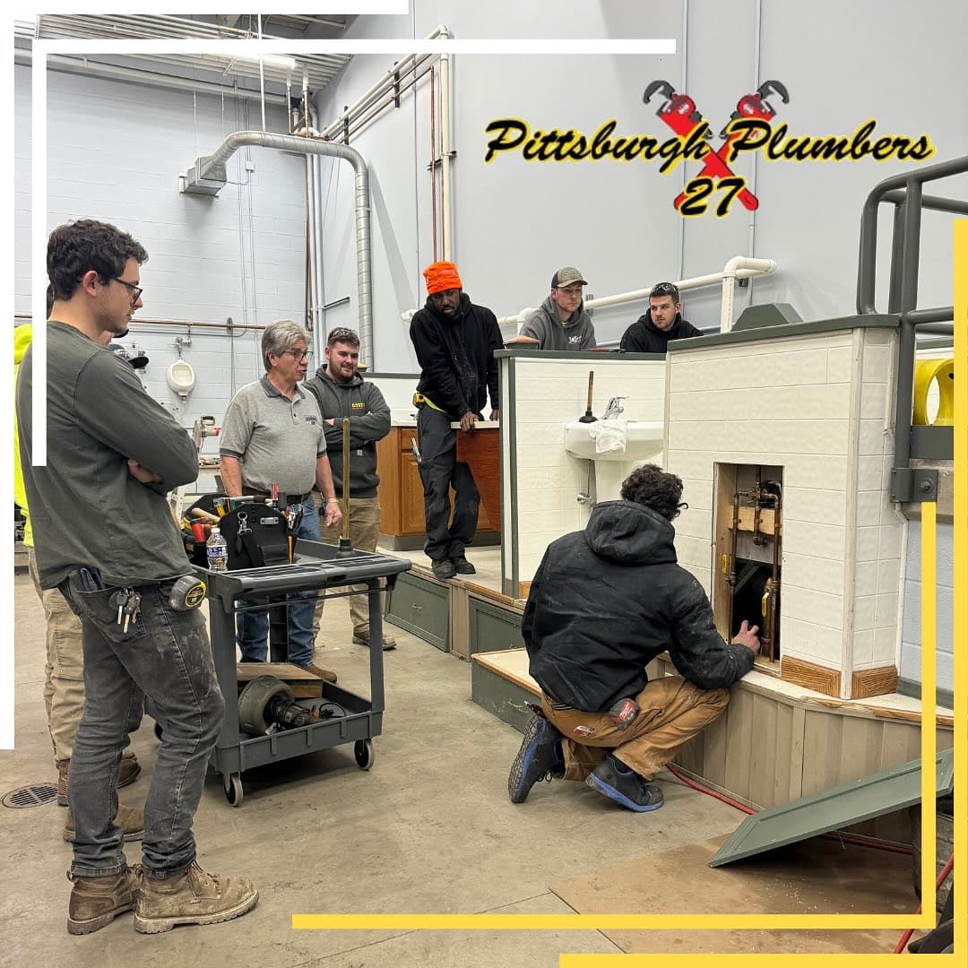 UA Local 27 apprentices working a rough-in on a training-hall test bathroom.